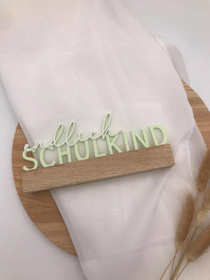 3D-gedruckter Schriftzug "endlich Schulkind" in Pastellgrün auf Holzsockel als Einschulungsdekoration
