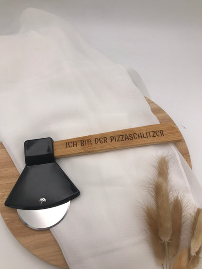Pizzaschneider Beil with engraved "Ich bin der Pizzaschlitzer" wooden handle and stainless steel blade on round wooden board