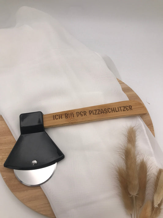 Pizzaschneider Beil with engraved "Ich bin der Pizzaschlitzer" wooden handle and stainless steel blade on round wooden board
