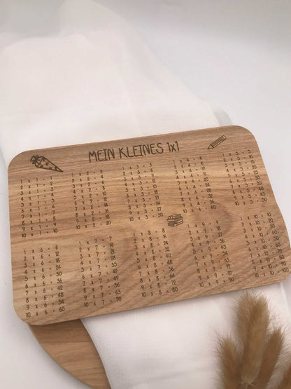 Einschulung Frühstücksbrettchen aus Holz mit 1x1 Malübersicht und Gravur "Mein kleines 1x1" als Frühstücksbrett für Kinder.