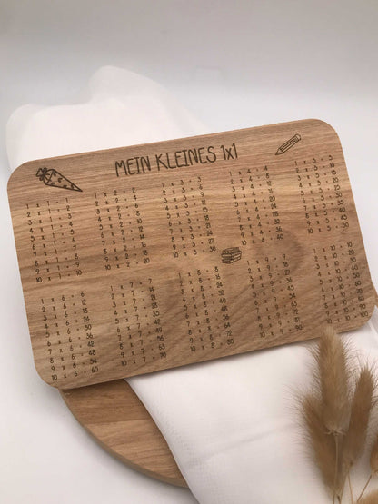 Frühstücksbrettchen aus Holz mit eingraviertem kleinen 1x1 und dekorativen Motiven zur Einschulung