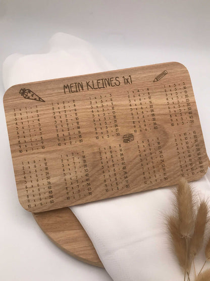 Frühstücksbrettchen aus Holz mit eingraviertem Einmaleins-Motiv und Schreiblern-Design, ideal zur Einschulung, handgefertigt und individuell