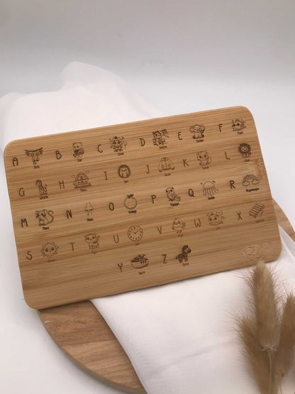 Frühstücksbrettchen aus Holz mit ABC-Gravur und kindlichen Illustrationen für die Einschulung