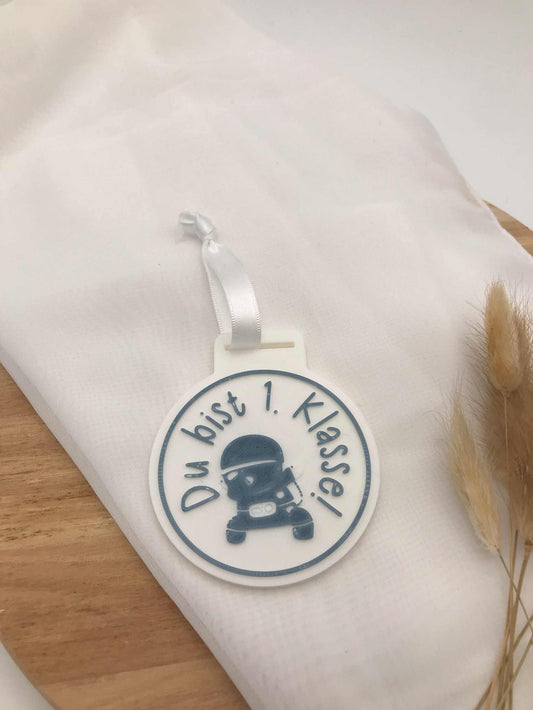 Medaille zur Einschulung aus 3D-Druck mit Wunsch-Spruch "Du bist 1. Klasse" als Geschenk zum Schulanfang in verschiedenen Farben und mit Band