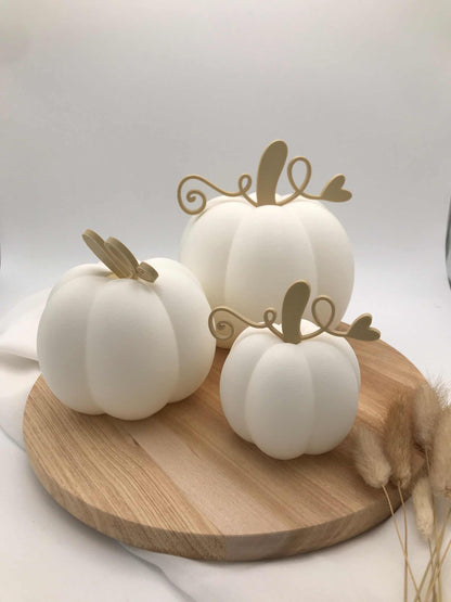 Set of three white decorative pumpkins in small, medium, and large sizes made from sustainable PLA 3D-printing with wooden stems, displayed on a round wooden tray.