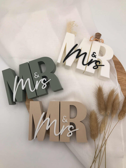 Drei 3D-gedruckte Mr & Mrs Schriftzüge als moderne Geldgeschenke zur Hochzeit in verschiedenen Farben mit Reagenzglas-Halterung.