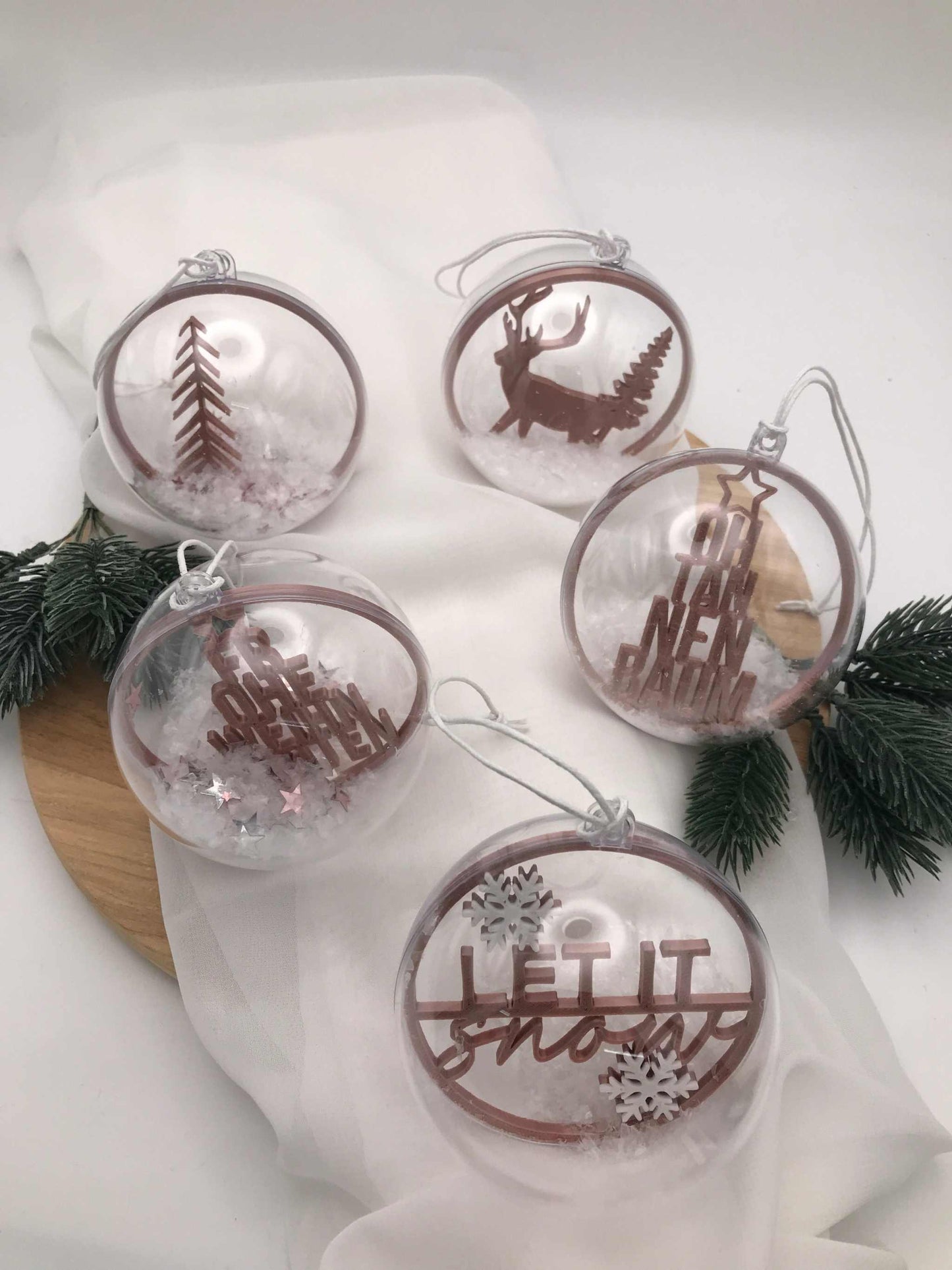 Transparente handgemachte Weihnachtskugeln mit winterlichen Motiven und Schnee-Effekt als festliche Acrylkugeln.