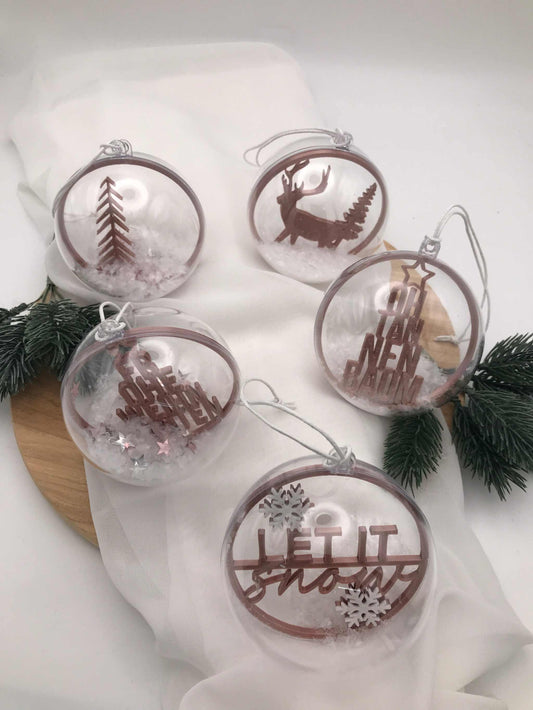 Transparente handgemachte Weihnachtskugeln mit winterlichen Motiven und Schnee-Effekt als festliche Acrylkugeln.