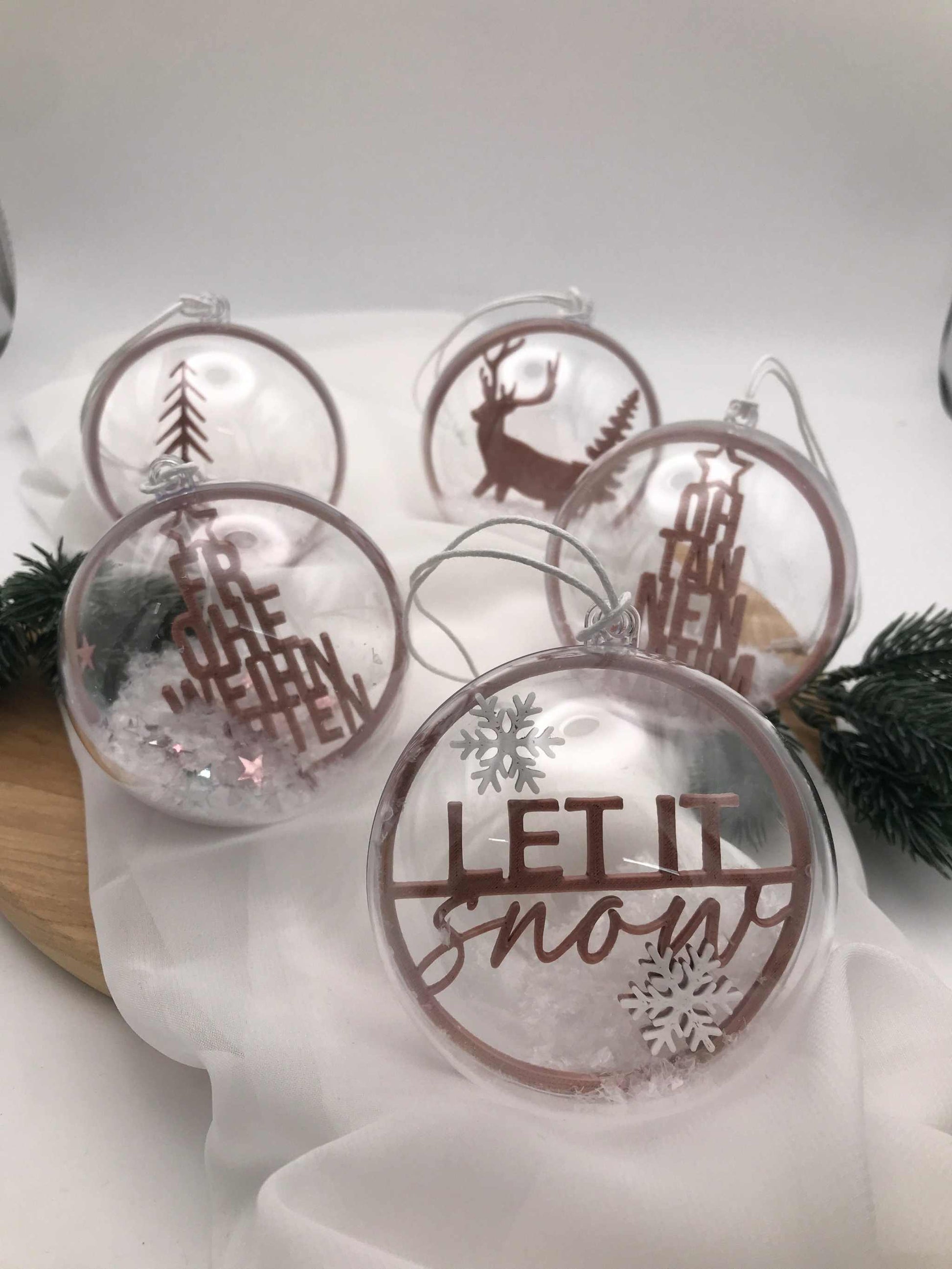Transparente handgemachte Weihnachtskugeln mit winterlichen Motiven und Schnee-Effekt als festliche Acrylkugeln.