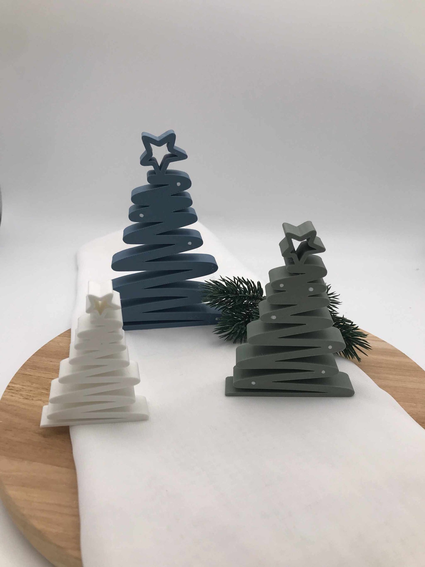 geschwungener Weihnachtsbaum aus 3D-gedrucktem PLA in Blau, Grün und Weiß als moderne nachhaltige Tischdeko