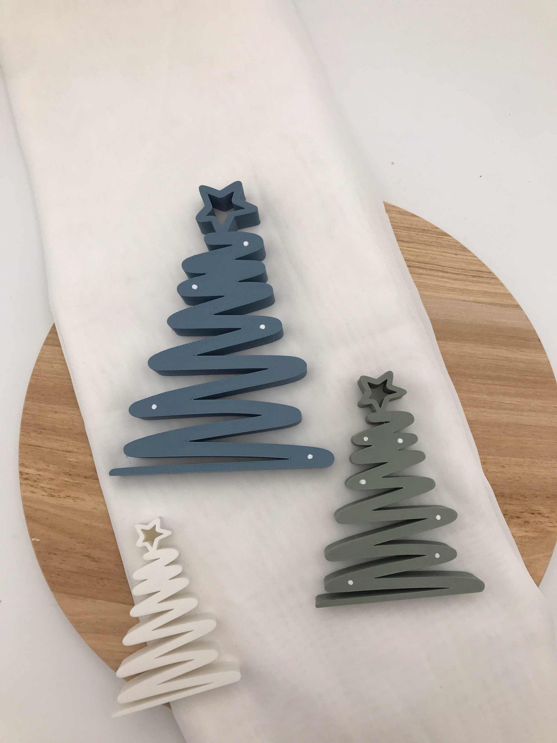 geschwungener Weihnachtsbaum aus 3D-gedrucktem PLA in Blau, Grün und Weiß als moderne nachhaltige Tischdeko