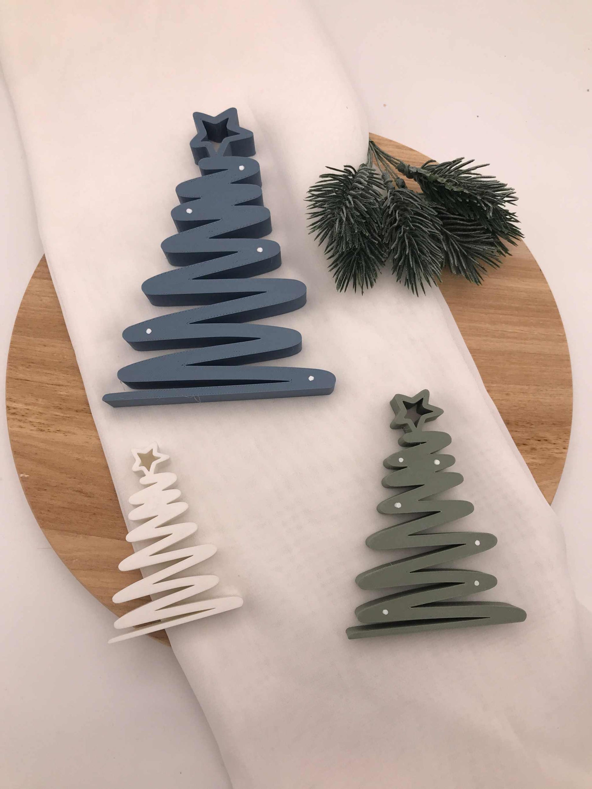 geschwungener Weihnachtsbaum aus 3D-gedrucktem PLA in Blau, Grün und Weiß als moderne nachhaltige Tischdeko