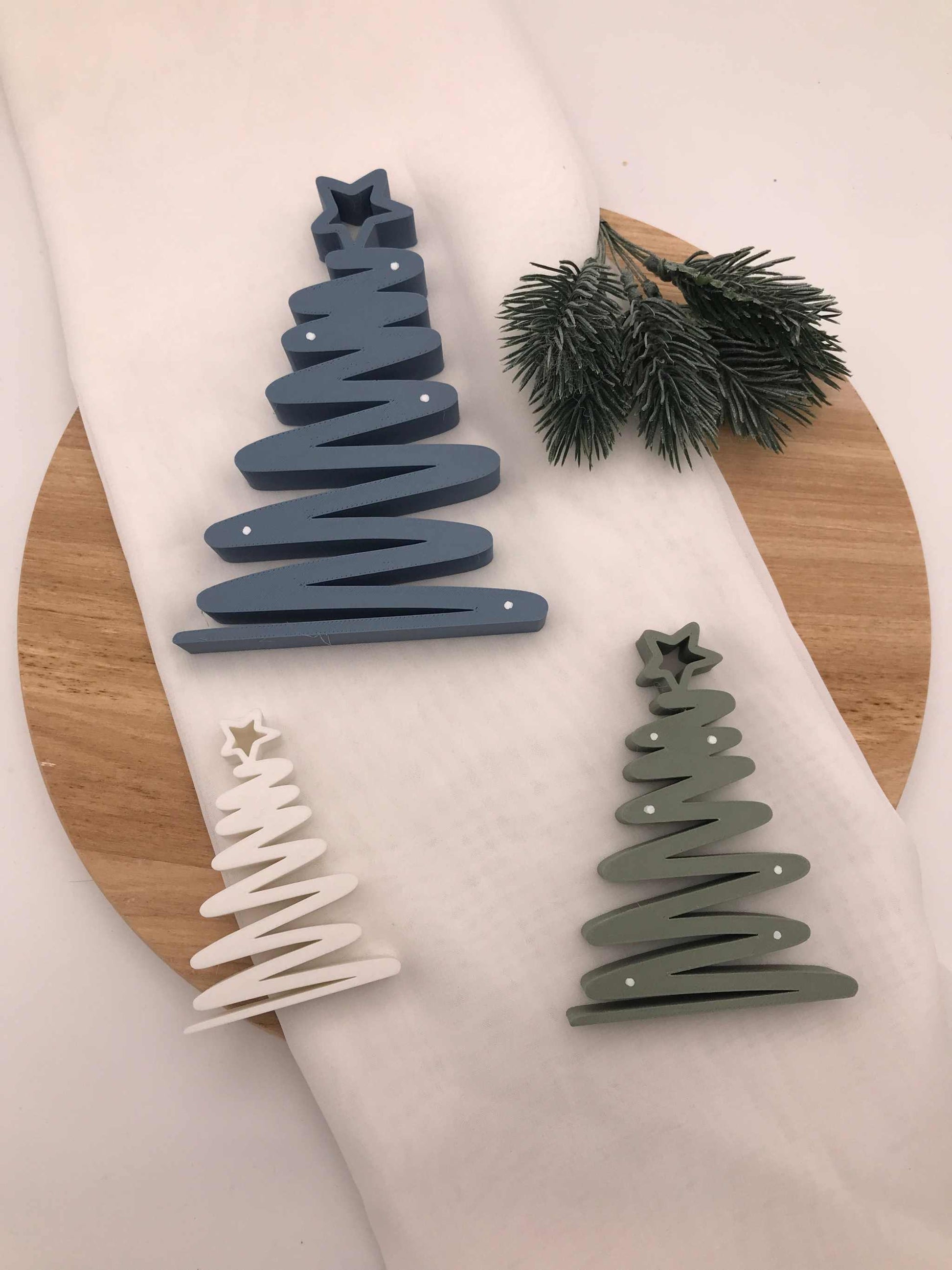 geschwungener Weihnachtsbaum aus 3D-gedrucktem PLA in Blau, Grün und Weiß als moderne nachhaltige Tischdeko
