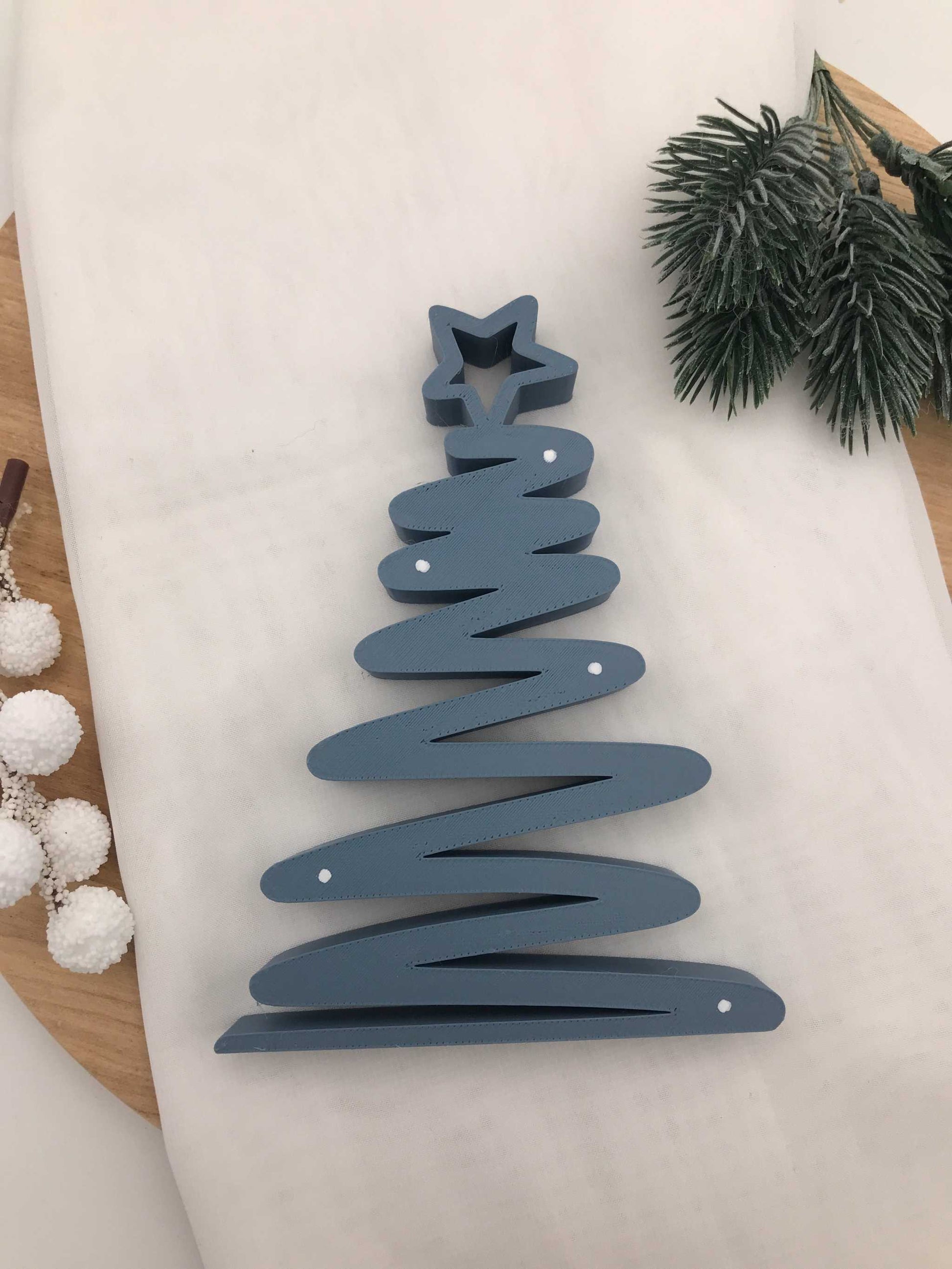 geschwungener Weihnachtsbaum aus 3D-gedrucktem PLA in Blau, Grün und Weiß als moderne nachhaltige Tischdeko
