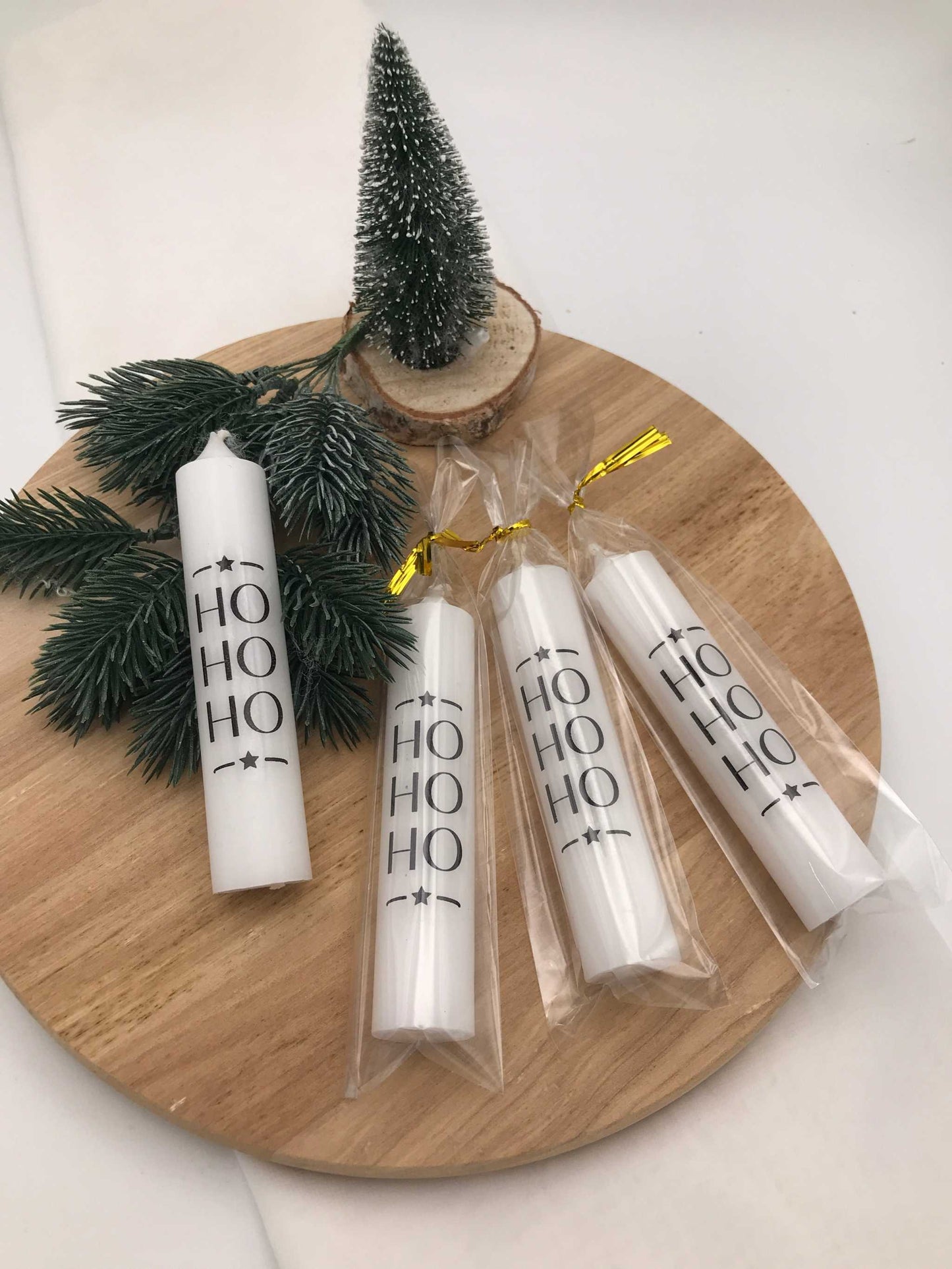 Festliche weiße Stabkerzen mit HO HO HO Schriftzug auf Holztablett dekoriert für Weihnachten