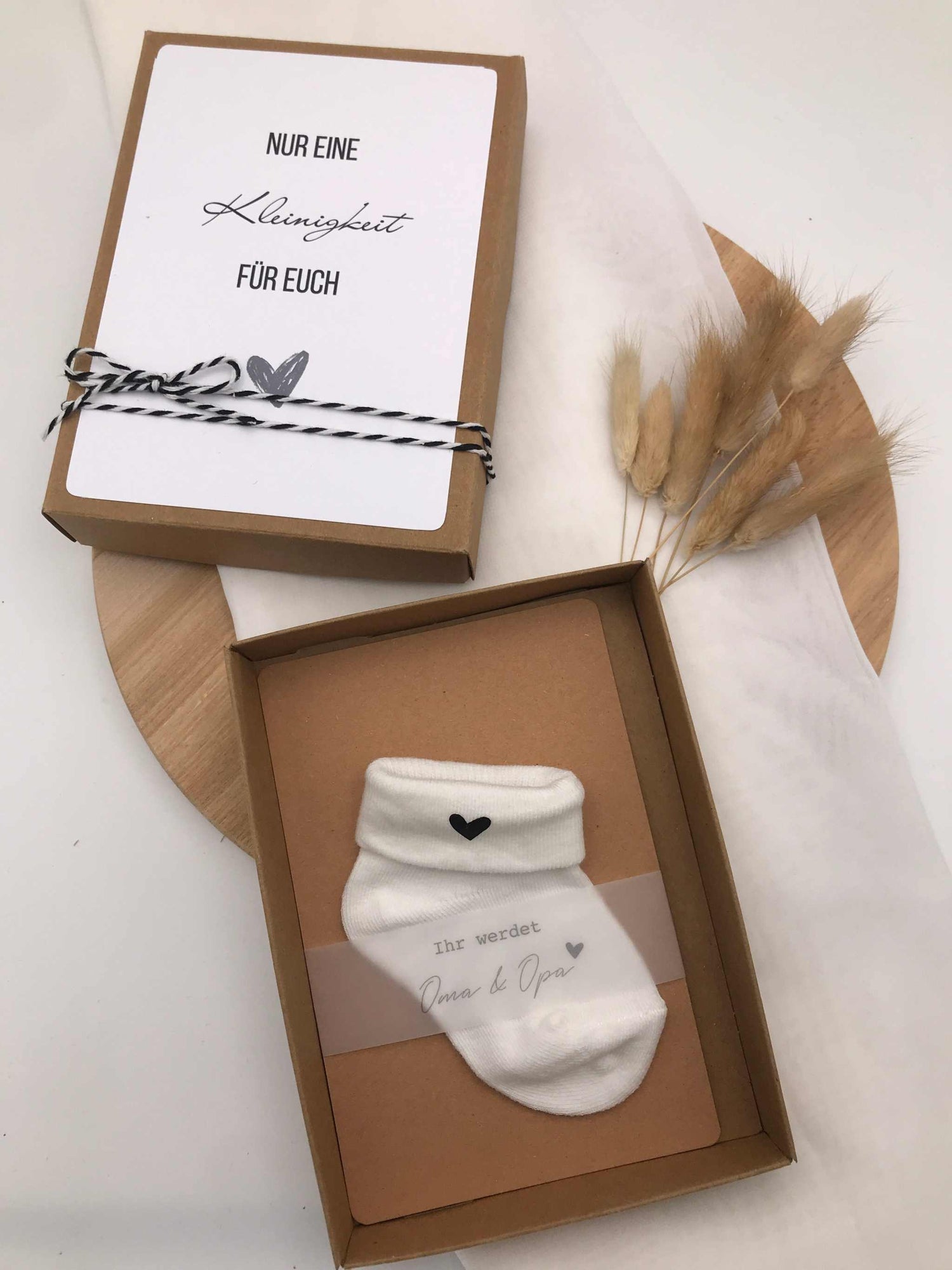 Kreative Schwangerschaftsankündigung Geschenkbox mit Baby-Söckchen und Herz auf Socke