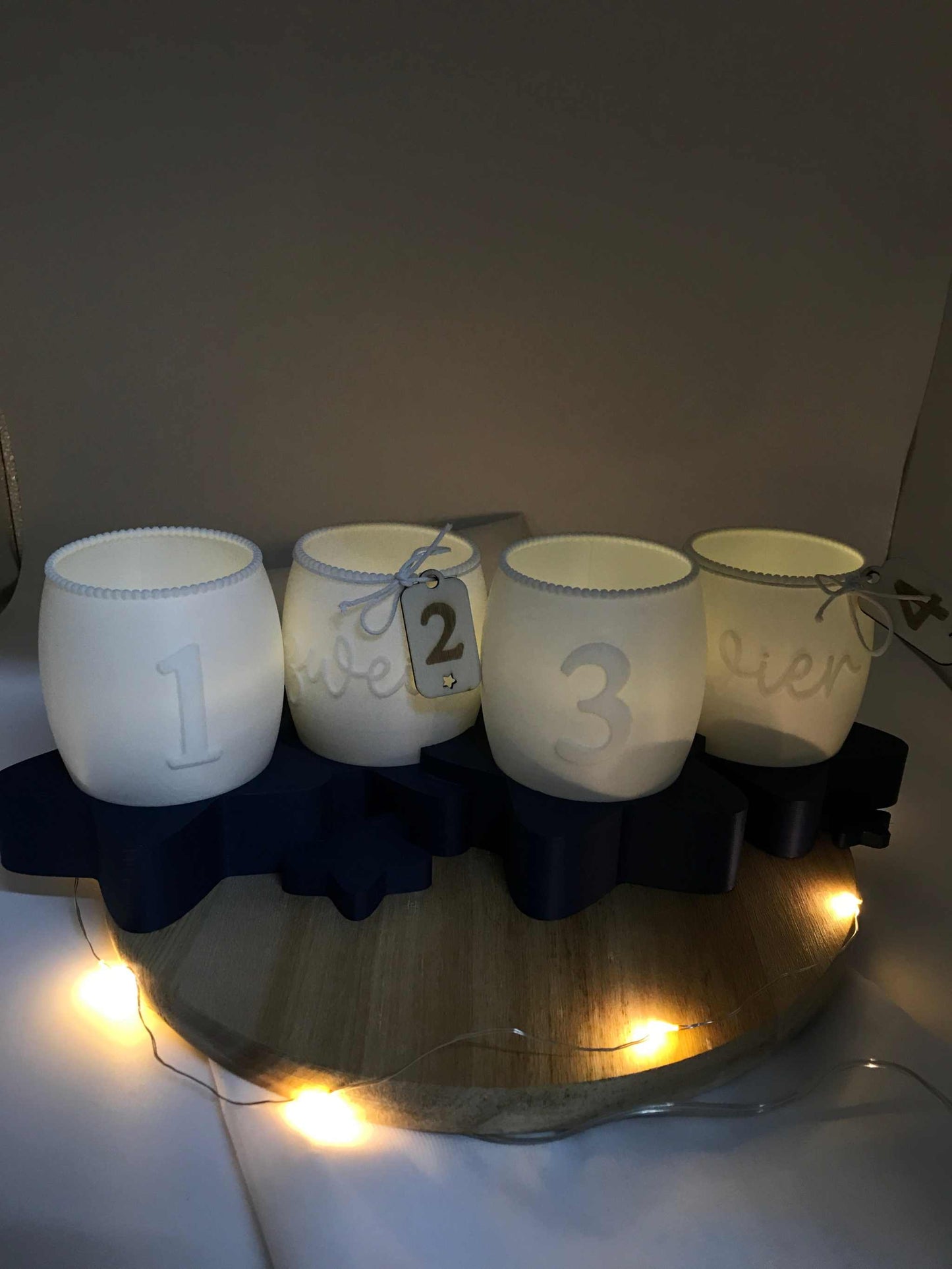 Moderner Adventskranz 3D Druck aus weißem PLA mit Zahlen 1 bis 4 auf dunkelblauem Sternenständer, umweltfreundliche Weihnachtsdeko