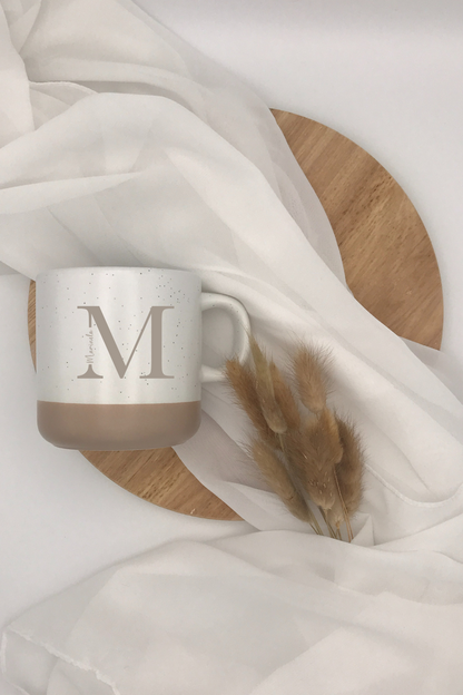 Keramiktasse personalisiert mit Buchstaben-Design, in Grau und Beige.