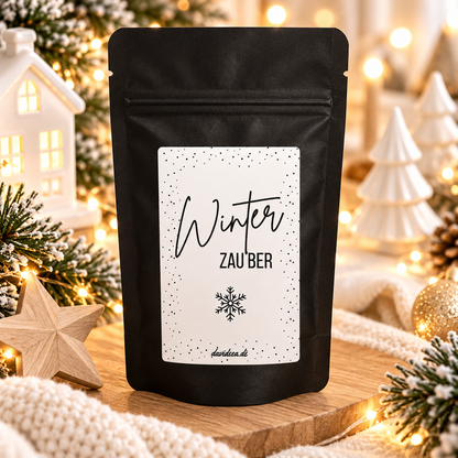 Weihnachtliche Kaffee-Geschenktüte in mattem Schwarz mit weißem Etikett, Schriftzug „Winterzauber“ und Schneeflocke