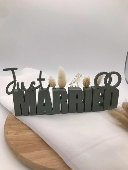 Tischaufsteller Just Married aus grauem PLA mit Trockenblumen in Aussparungen, eleganter Schriftzug für Hochzeit