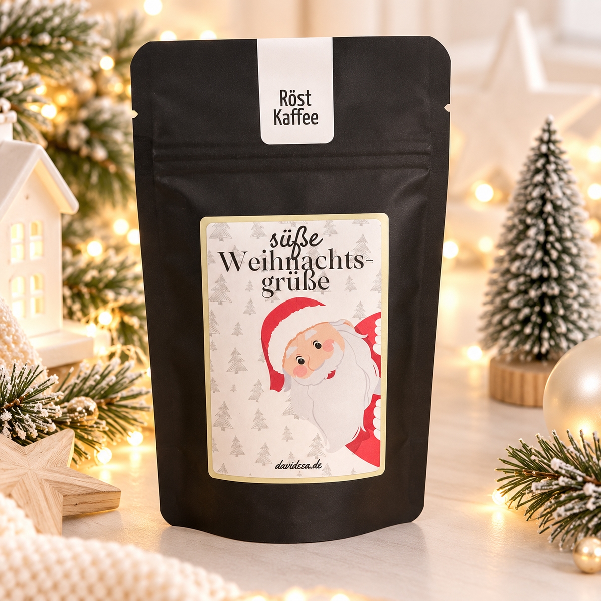 Kaffee in schwarzer, matter Geschenktüte mit weihnachtlichem Etikett, Tannenbaummuster und fröhlichem Weihnachtsmann