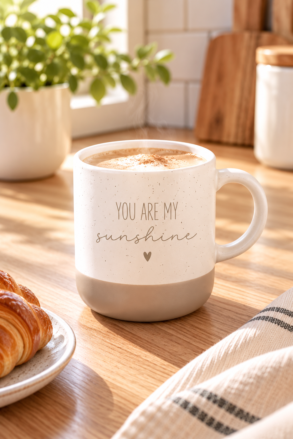 Kaffeetasse aus beiger Keramik mit grauem Fuß, feinem Sprenkelmuster und dem Schriftzug „You are my sunshine“