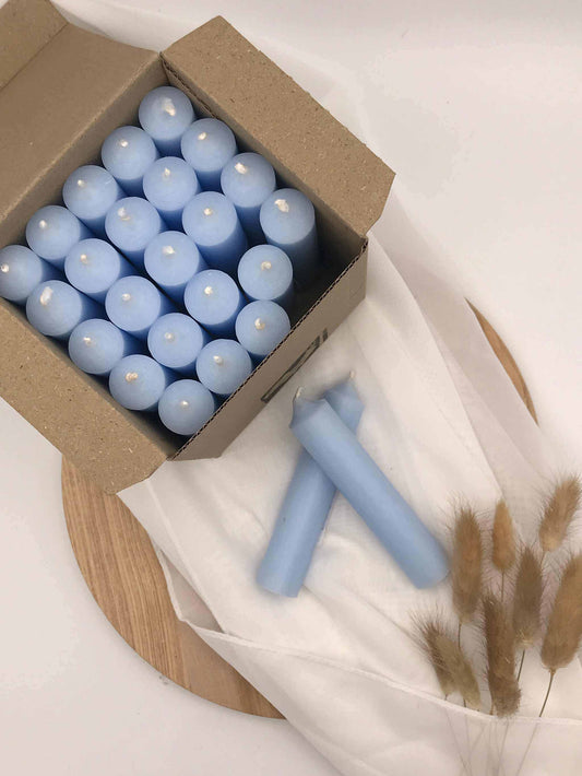 Kerzen als hellblaue Stabkerzen aus glattem, durchgefärbtem Wachs, dicht in einem offenen Karton verpackt
