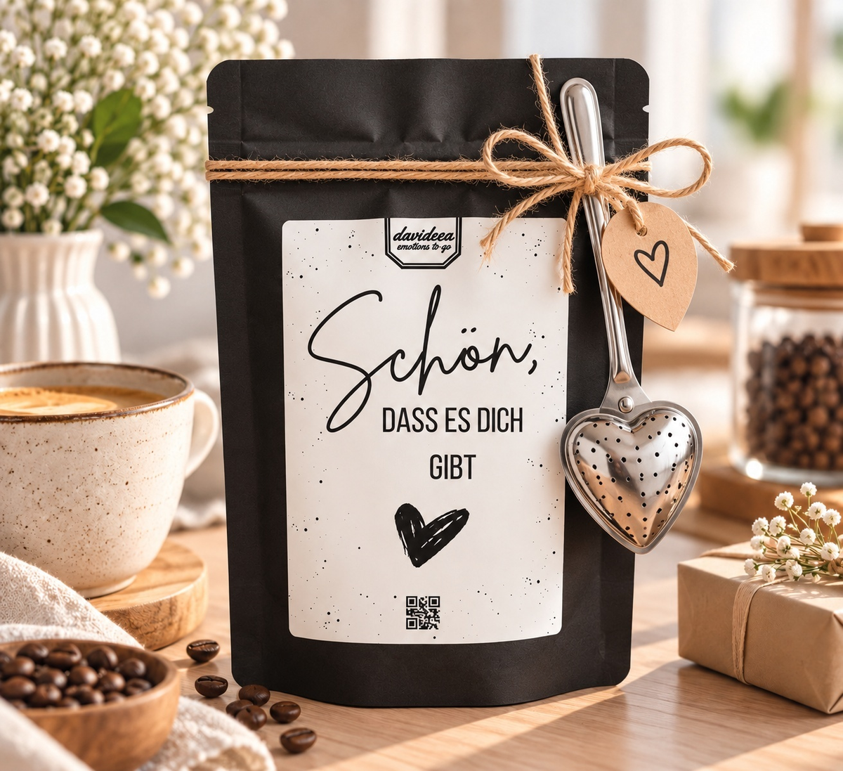 Schwarze Geschenktüte mit Kaffee oder Tee und Herz-Teesieb
