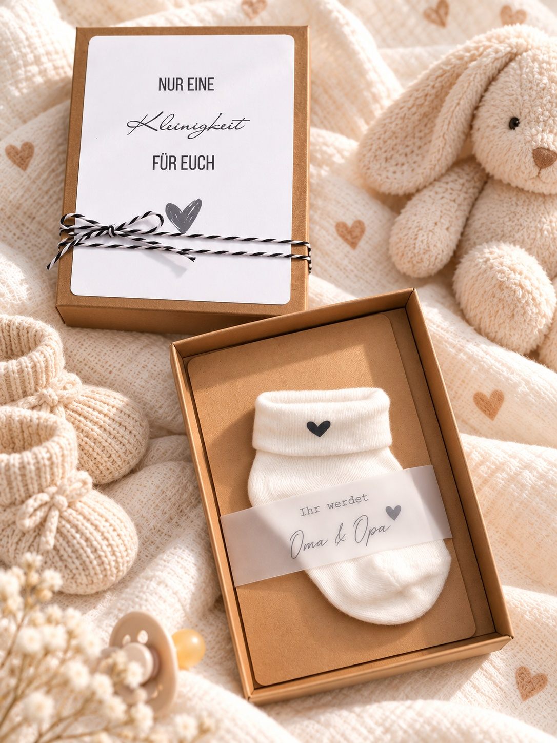Schwangerschaft Geschenkbox aus braunem Kraftpapier mit weißer Babysocke und Herz sowie Botschaft für Oma und Opa