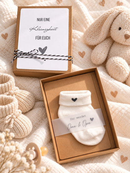Schwangerschaft Geschenkbox aus braunem Kraftpapier mit weißer Babysocke und Herz sowie Botschaft für Oma und Opa