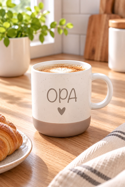 Tasse aus beiger Keramik mit braunem Fuß, schwarzem Sprenkelmuster und Aufdruck „OPA“ mit Herz