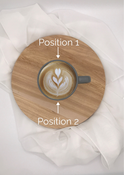 Tasse aus grauer Keramik mit Henkel, gefüllt mit Kaffee und herzförmiger Latte-Art im Milchschaum