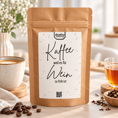 Weihnachtsgeschenk Kaffee Tee: braune Kaffeetüte aus Kraftpapier mit weißem Etikett und Spruch „Kaffee, weil es für Wein zu früh ist“.