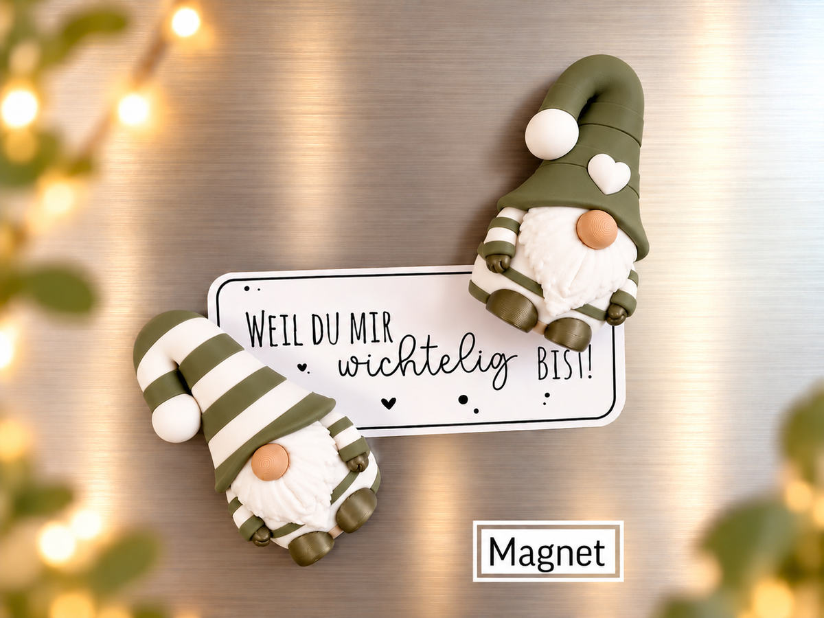 Wichtel Magnet aus Kunststoff mit olivgrünen und weißen Streifen, weißem Bart, Knubbelnase und Herz auf der Mütze